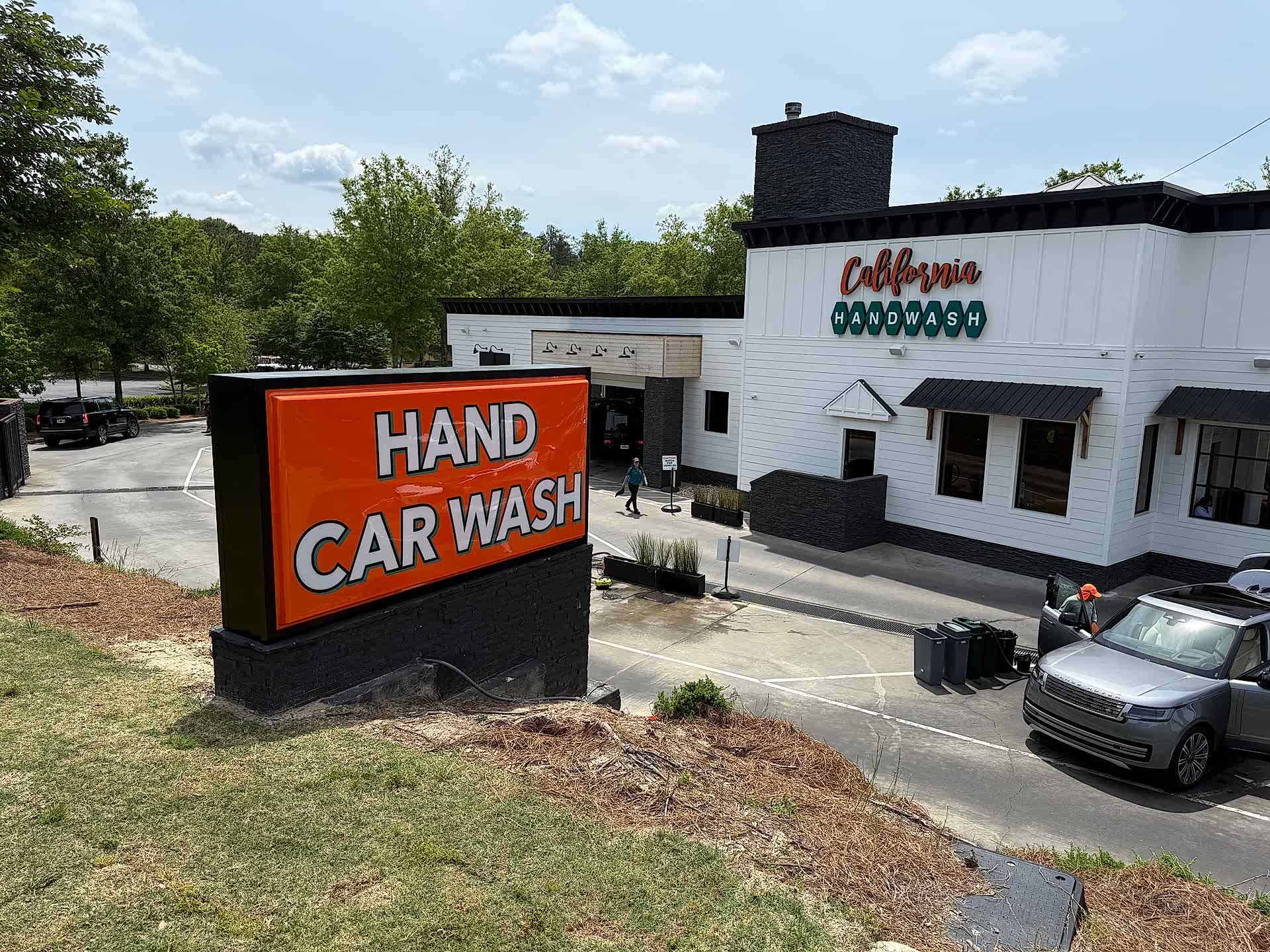 Street view of the California Hand Wash monument sign, catching the eye of passing traffic with sleek design and bold lettering.