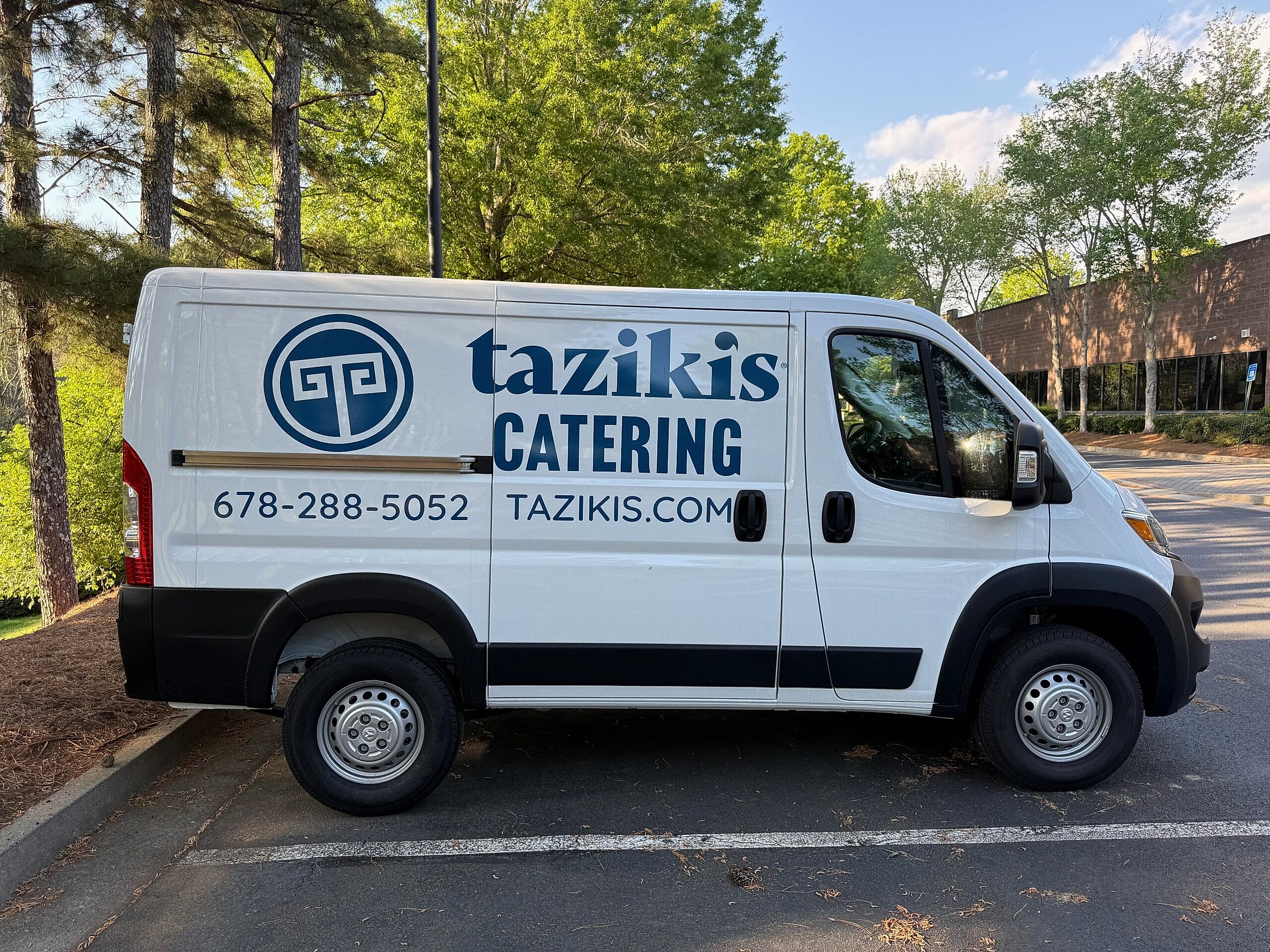 Catering van for Taziki’s in Johns Creek, GA featuring spot graphics and vinyl lettering on the sides for clear, on-the-road branding.